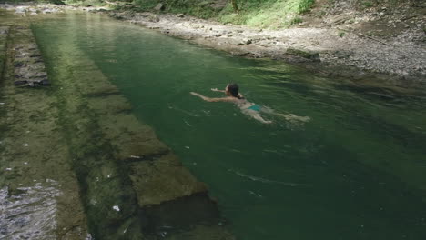 mujer nadando en una piscina natural