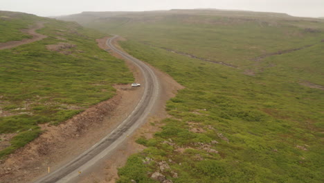 Luftaufnahme-Eines-Autos,-Das-Auf-Einer-Kurvenreichen-Straße-Durch-Islands-Einsame-Westfjorde-Fährt