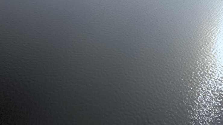 Drone flying low and fast along surface of rippled water with sunlight reflections