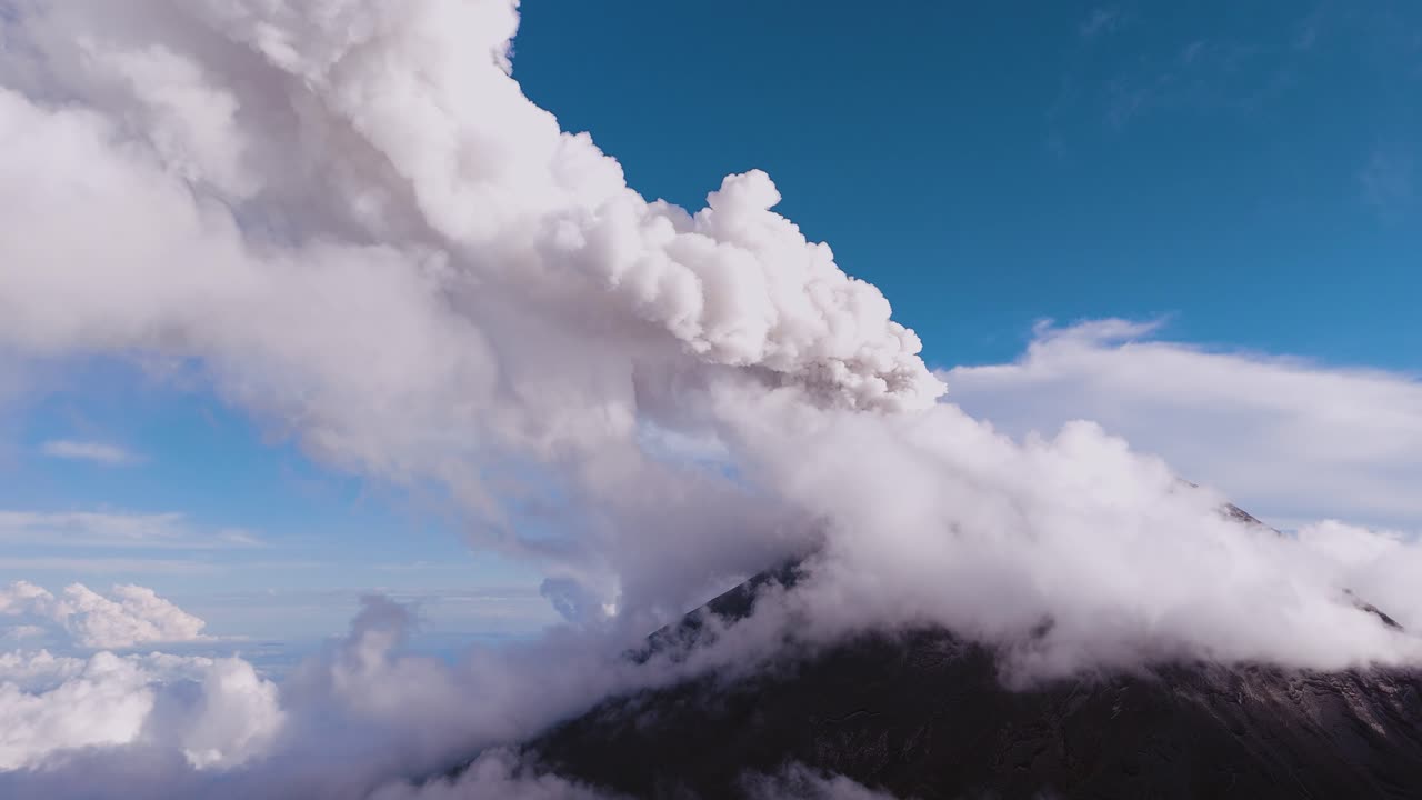Aerial view of steam rising fumarole from Popocatépetl volcano covered by white clouds, Mexico