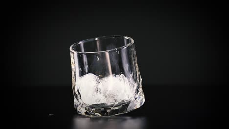 el cubo de hielo cae en un vaso.