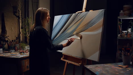 woman painting abstract art in a studio