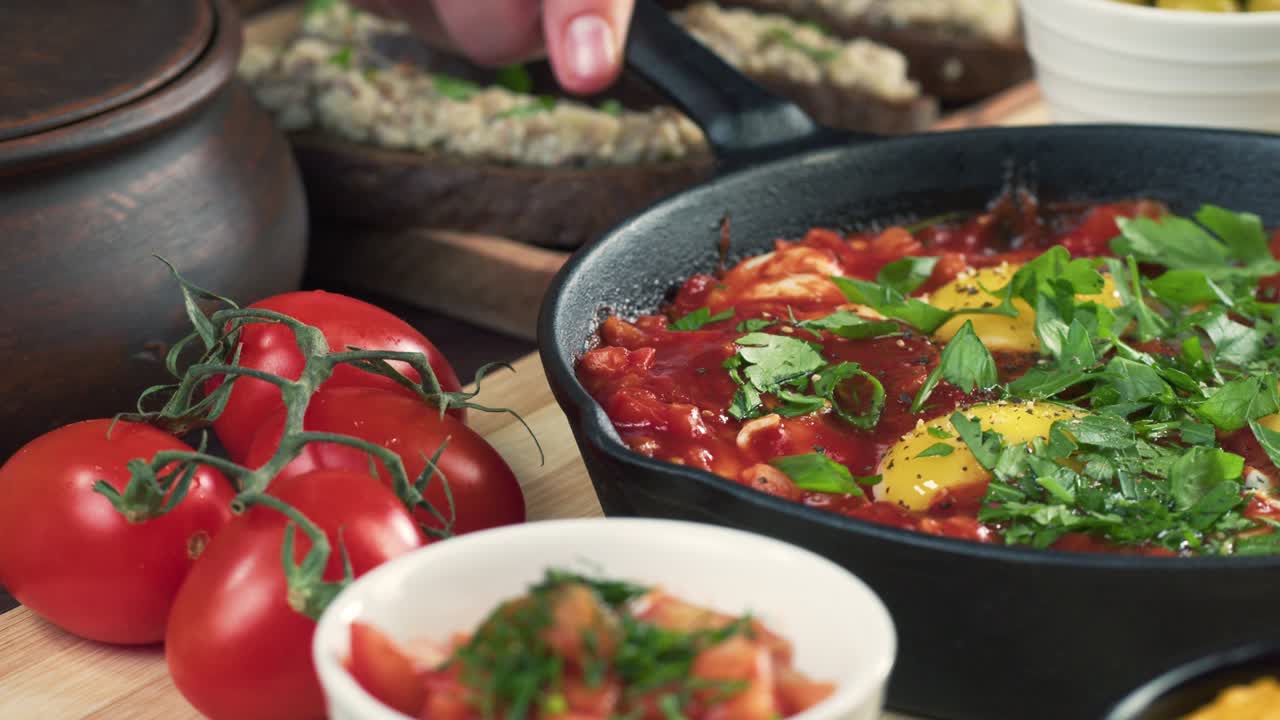cocina israelí. shakshuka decorado con perejil de primer plano. plato nacional judío hecho de huevos fritos en salsa de tomate, pimientos picantes, cebollas y especias, cultura de oriente medio, chakchouka