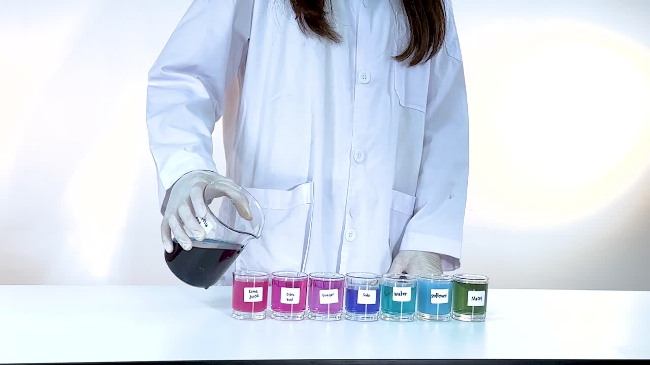 Scientist pours liquid into test tubes, observing color changes. Bright lighting highlights the chemical reaction process
