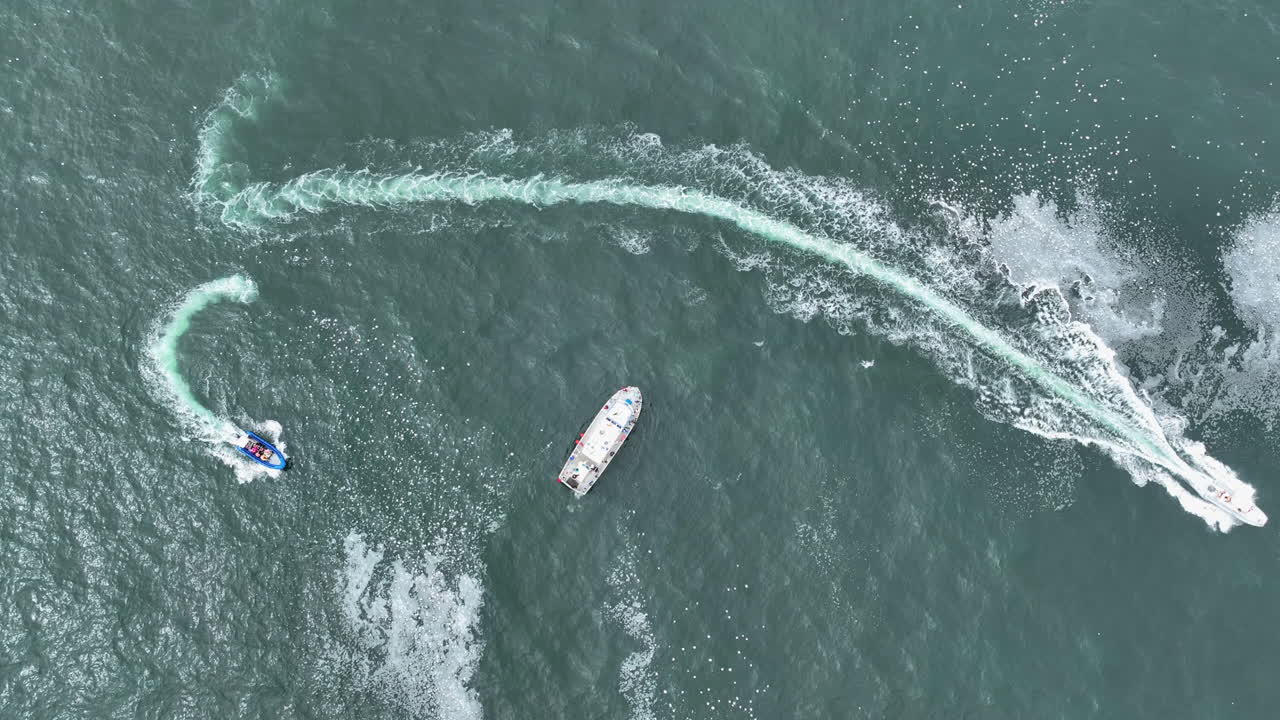 Top down drone shot rising above whale watching boats in cloudy Oregon, USA