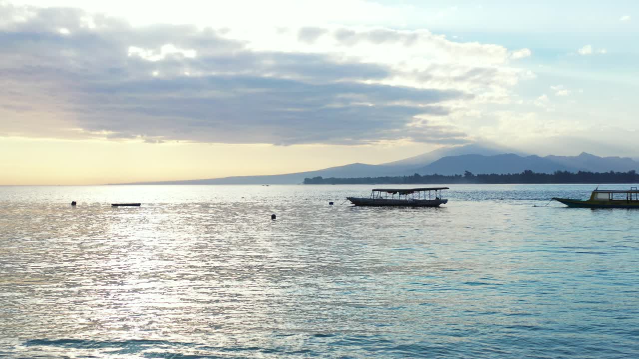 Samoa Island - Boats floating on the calm sea under the cloudy skies with mountain stretch on the background - Wide Shot