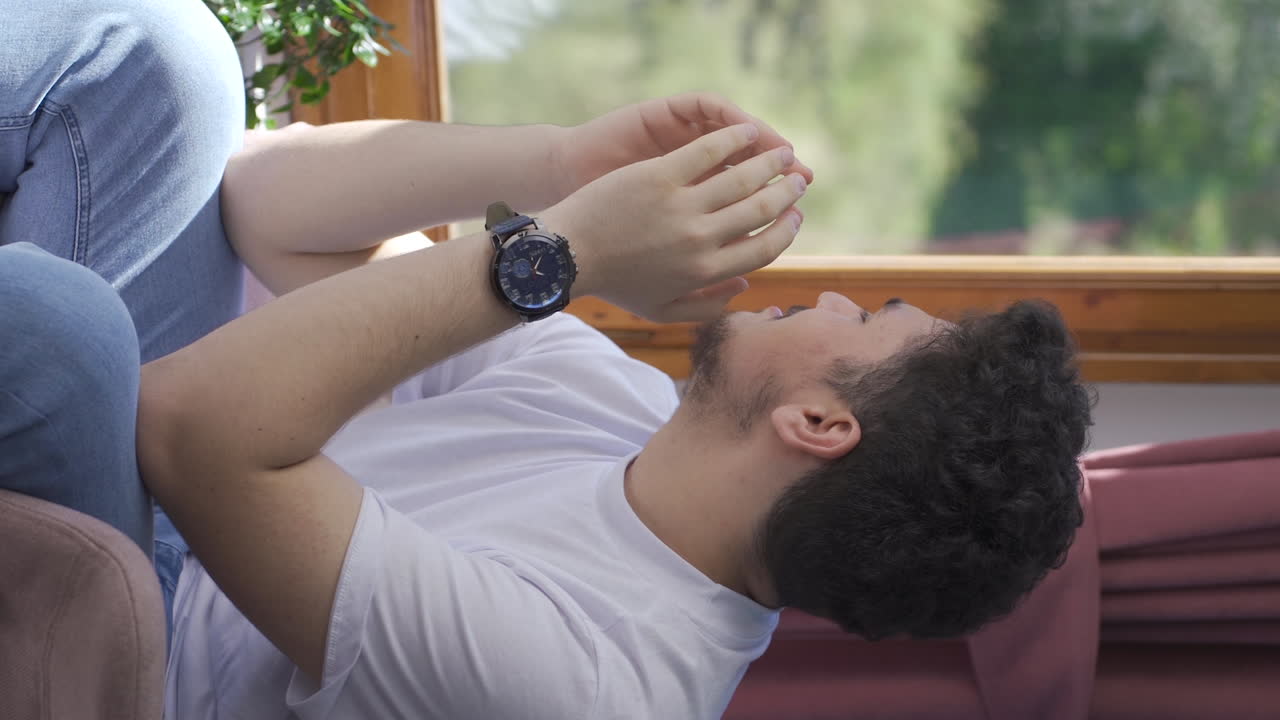 vídeo vertical de un hombre llorando solo en casa.