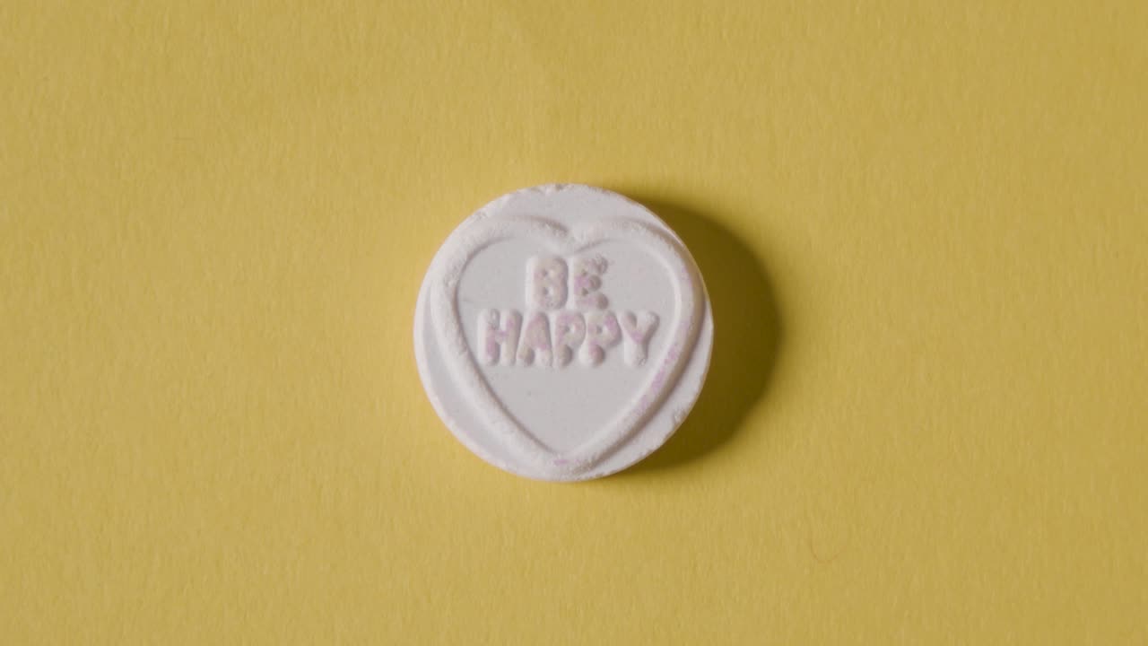 노란색 배경에 행복 메시지가 있는 하트 캔디