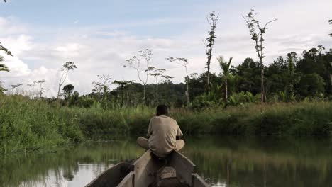 Indigener-Mann-Mit-Blick-Nach-Vorne-Auf-Einem-Boot,-Das-Sich-Im-Papua-Dschungelfluss-Bewegt