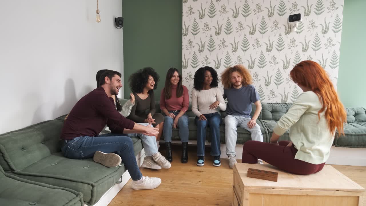 Happy woman gossiping with diverse friends at home