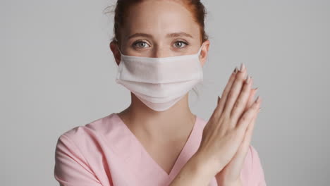 redheaded doctor in front of camera on gray background.