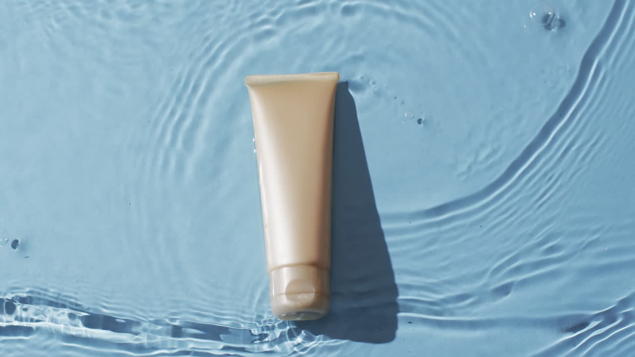Video di un tubetto di prodotto di bellezza in acqua con spazio per il testo su sfondo blu