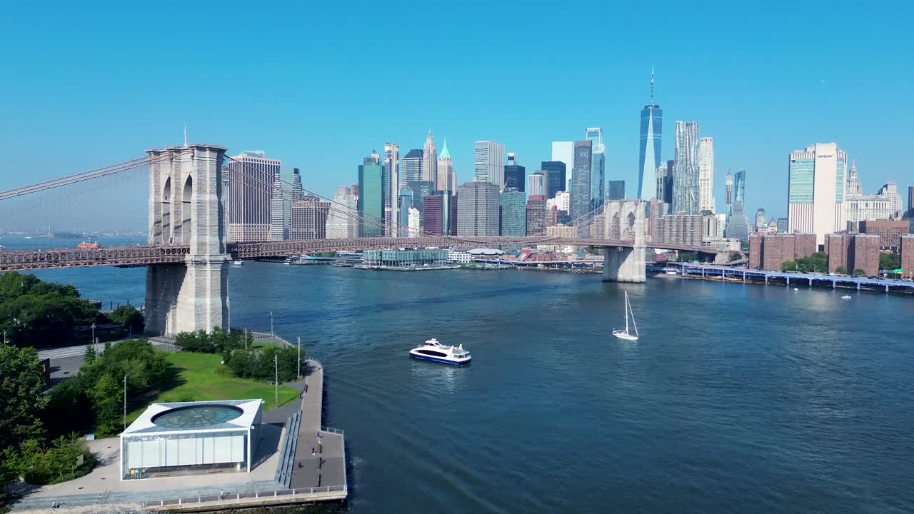 브루클린 브릿지 (brooklyn bridge) 아래를 지나가는 배 페리 (ferry) 의 무인기 공중 풍경 뉴욕 시 cbd 스카이 라인 맨해튼 미국 이스트 리버 인프라 건물