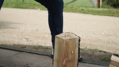 young man is chopping wood in smaller pieces