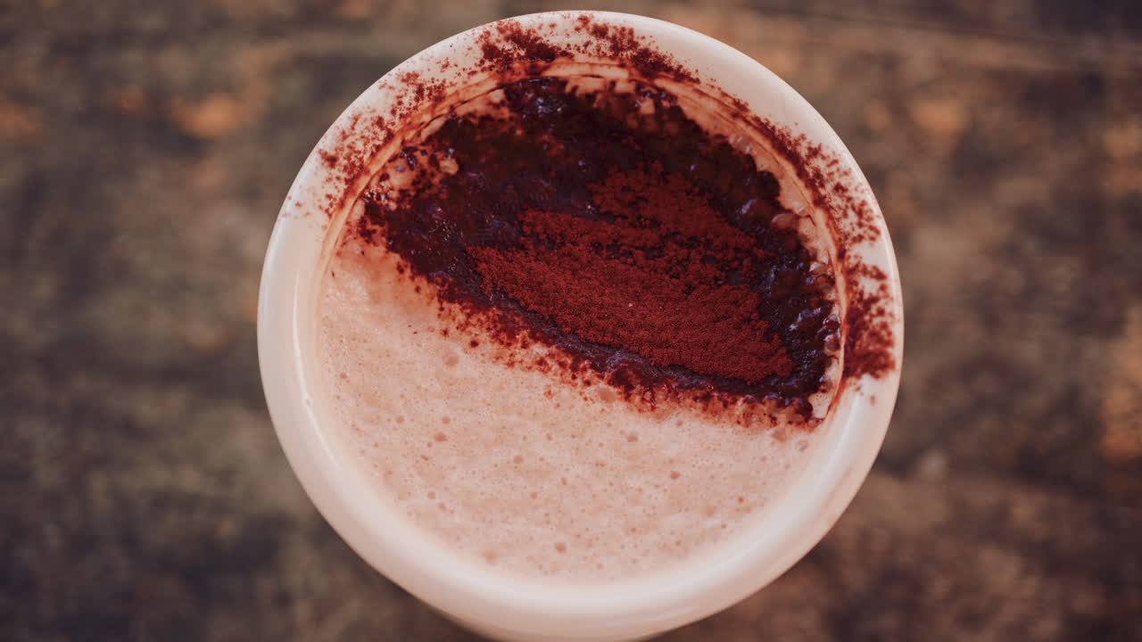 Close up of a rich hot chocolate or coffee surface sprinkled with cocoa powder