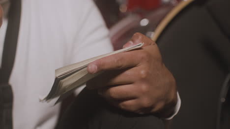 close up view of latin manâ¬â¥s hands writing in the notebook in recording studio