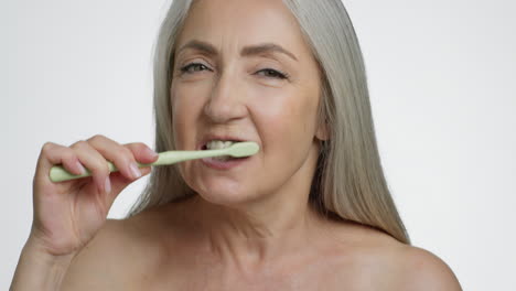 senior woman brushing her teeth
