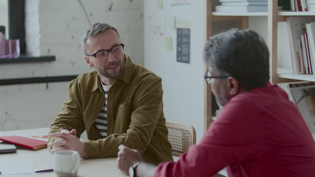 Businessman Having Conversation about Work with Colleague in Office