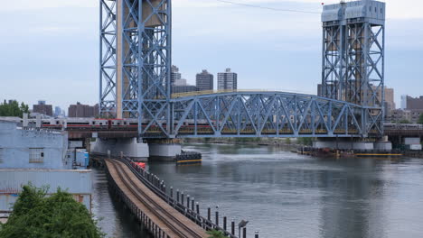 Crisp-steadycam-ground-stationary-shot-of-commuter-trains-crossing-on-the-Park-Avenue-Bridge-between-The-Bronx-and-Harlem-Manhattan-New-York-City