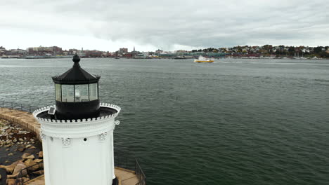 gorgeous aerial shot of bug light lamp with a ferry cruising past the city in the background