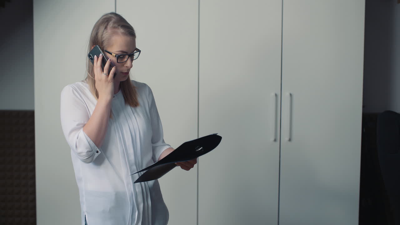 mujer concentrada hablando por teléfono con un cliente