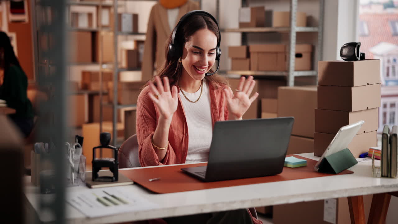 Mujer sonriente con auriculares trabajando en laptop en oficina de e-commerce