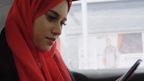 animación de una mujer asiática en hijab usando un teléfono inteligente sobre el paisaje urbano