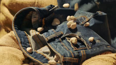 pumice-stones-are-falling-on-jeans-in-slow-motion