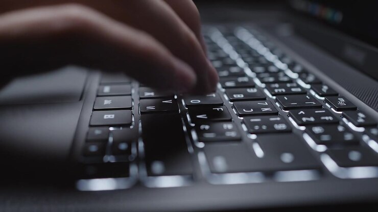 Nahaufnahme einer hinterleuchteten Laptop-Tastatur mit geringer Tiefenschärfe