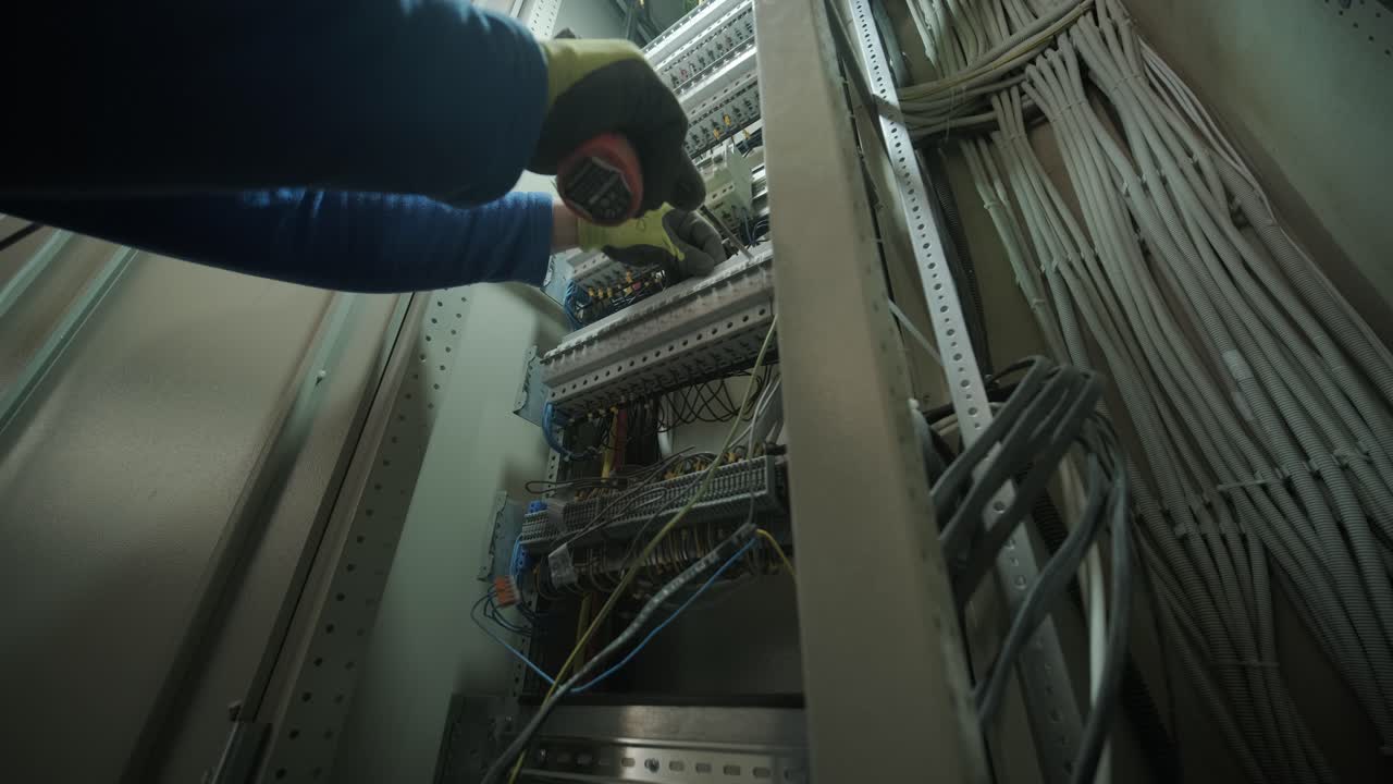 Elektriker arbejder på automatsikringer inde i en styretavle