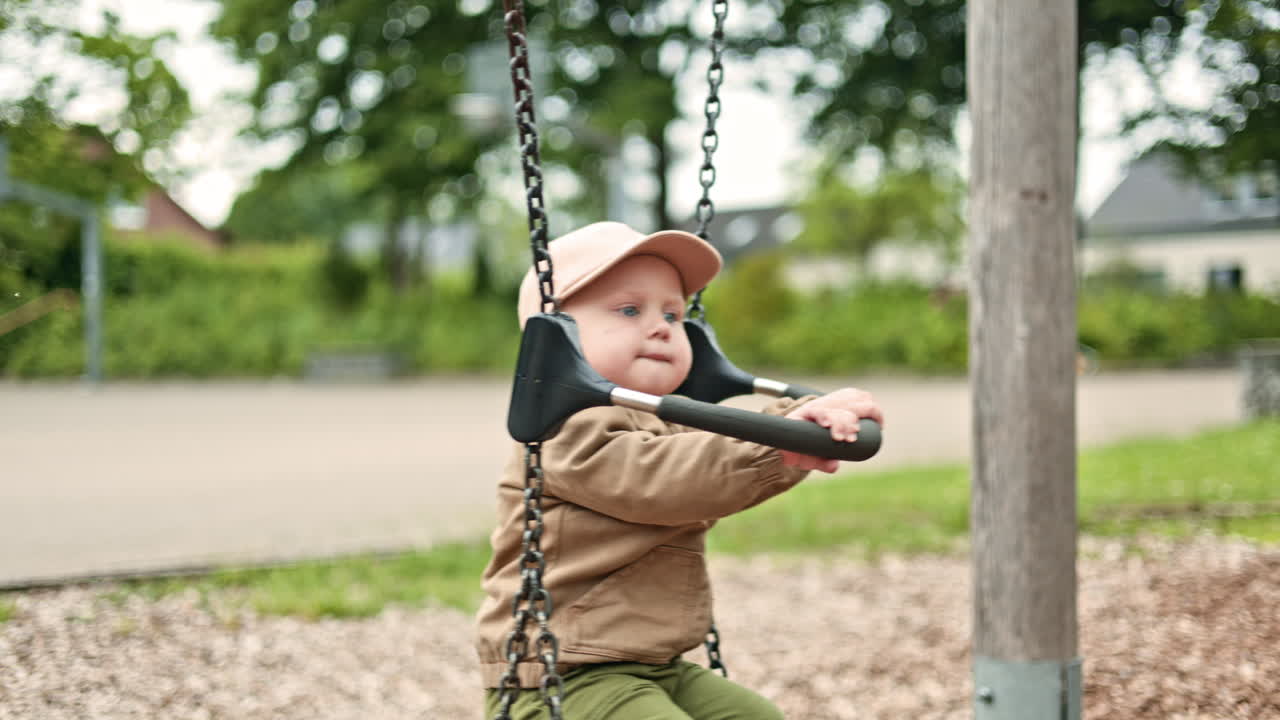 Un bambino carino che si dondola su un'altalena in un parco giochi. Bambino che gioca sull'altalena all'aperto. Attività all'aperto per bambini