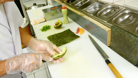 Male-chef-cutting-avocado-fruit-in-kitchen-4k