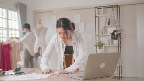 young asian couple of fashion designers working in fashion design studio