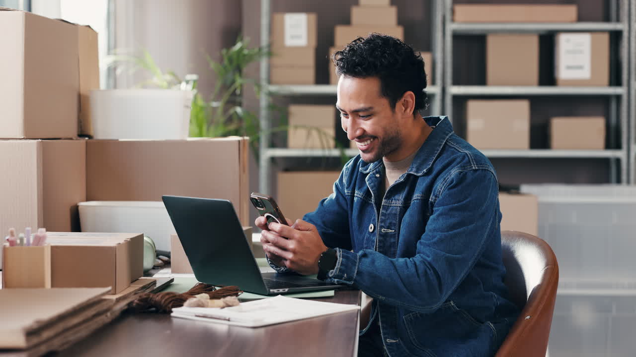 Uomo sorridente che usa telefono e laptop in un ufficio e-commerce