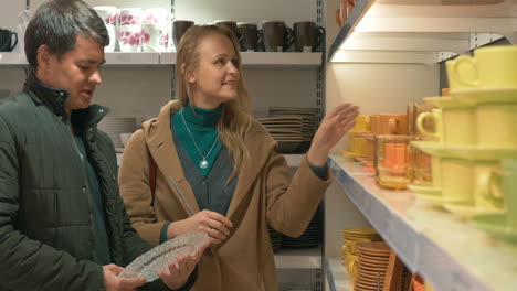 Young-couple-looking-at-dinnerware-in-the-shop