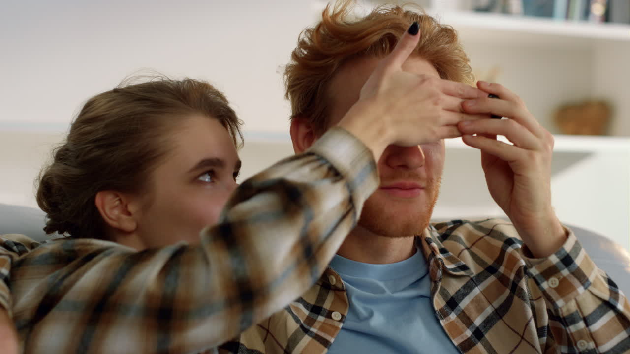 아내가 주말에 영화를 보고 있는 남편. 즐거운 가족이 휴식을 취하고 재미를 즐기고 있습니다.