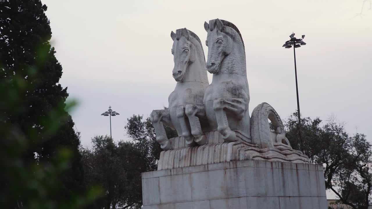revelación de una estatua de caballos con árboles en primer plano y al fondo