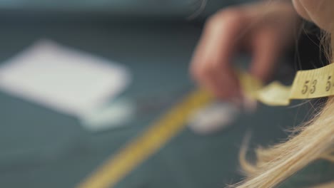 seamstress using fibreglass tape measure