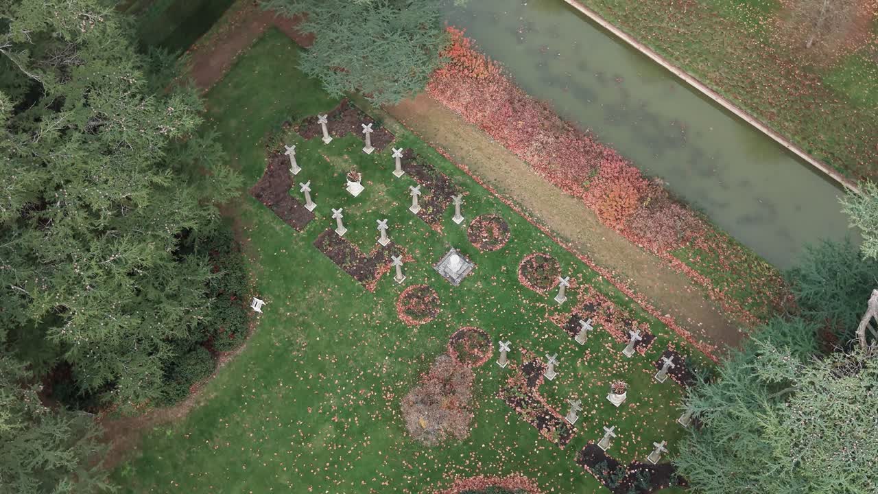 Kentwell hall mansion estate graveyard and moat covered in fallen Autumn leaves aerial view