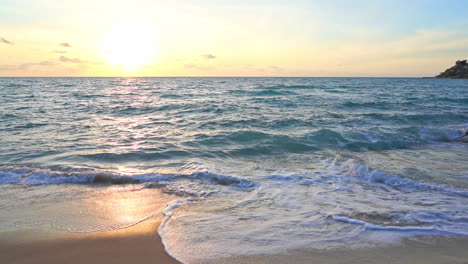 slow-motion of waves crashing on beach and sunlight reflections on sea surface