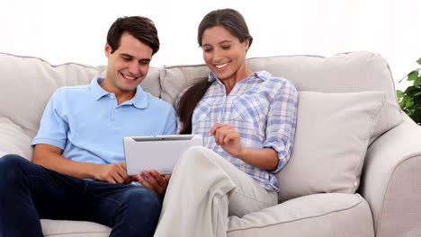 una pareja joven usando una tableta.