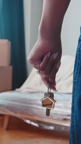 keys to apartment with keychain in shape of house in hands of woman realtor