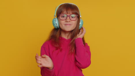 Happy-preteen-child-girl-kid-listening-music-via-headphones-and-dancing-disco-fooling-around