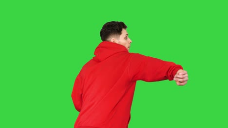joven guapo bailando con capucha roja en una pantalla verde, llave cromada