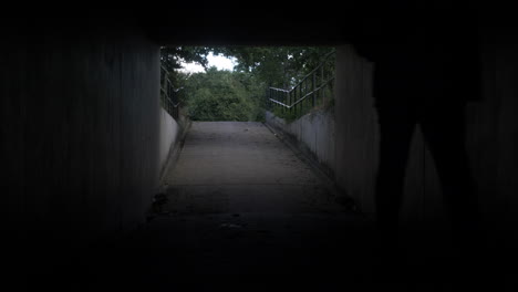 Silueta-De-Macho-Adulto-Entrando-En-El-Paso-Subterráneo-Del-Túnel-Oscuro