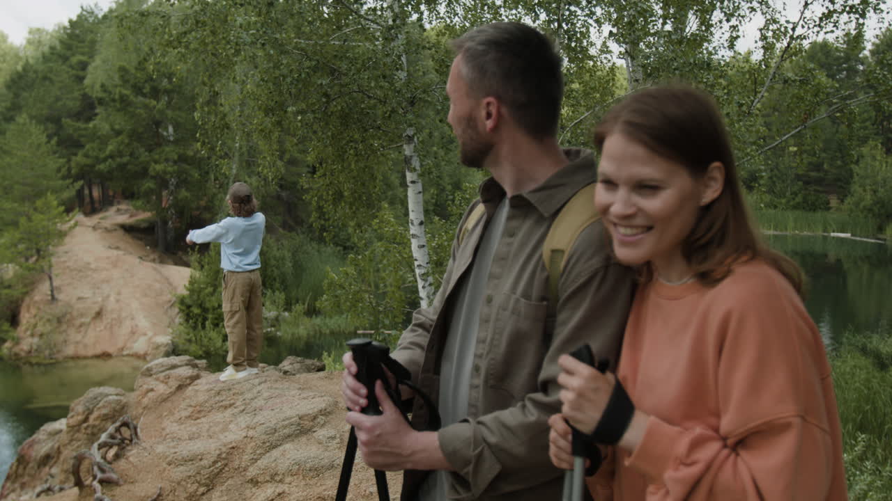 Family hiking near a lake in a forest