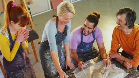 drawing teacher assisting artists in molding clay 4k