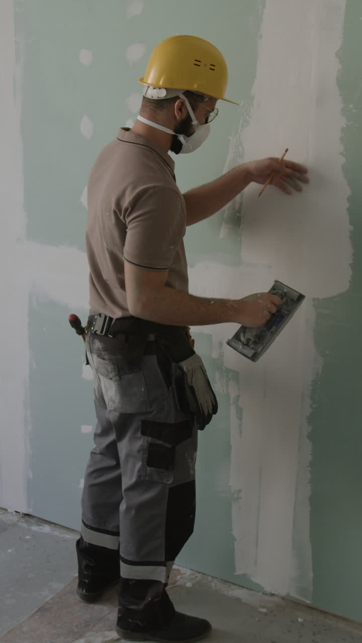 Construction worker plastering drywall