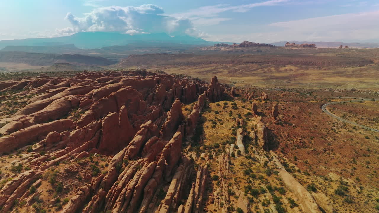 Flat rocks of beautiful canyons on sunny hot day. Huge cloudscape over the mountains at backdrop. Top view.