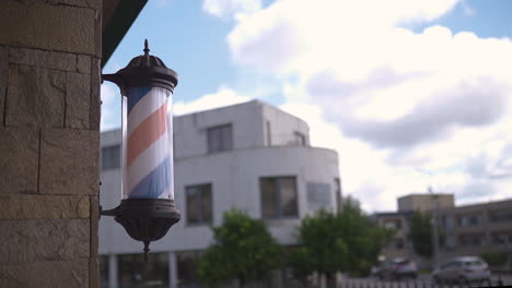 Barber&#39;s-Pole-Dreht-Sich-An-Der-Wand-Eines-Friseursalons-Mit-Blauem-Himmel-Und-Wolken-Im-Hintergrund